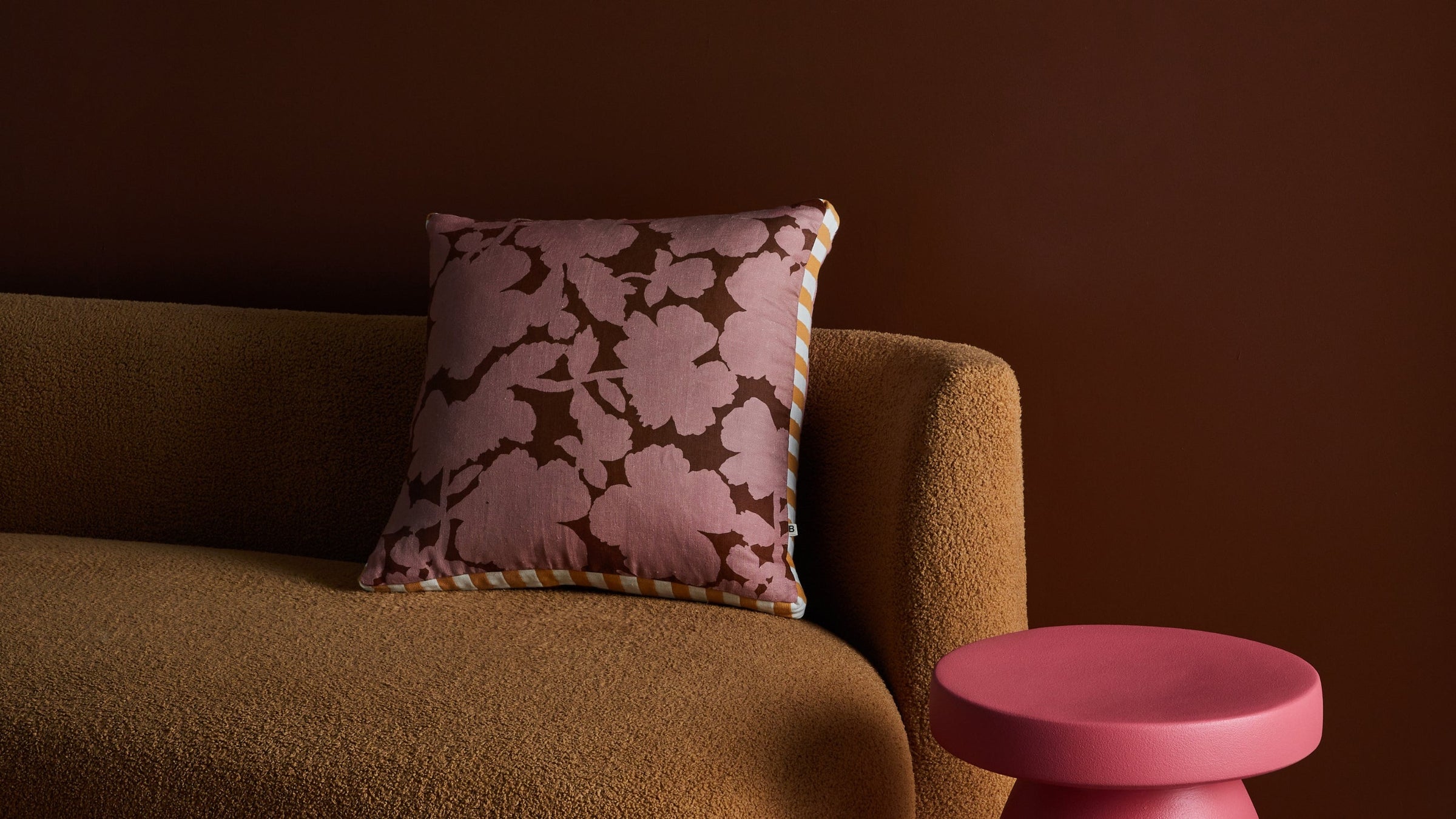 Daphne Rose Cushion | Pink floral cushion styled on tan sofa