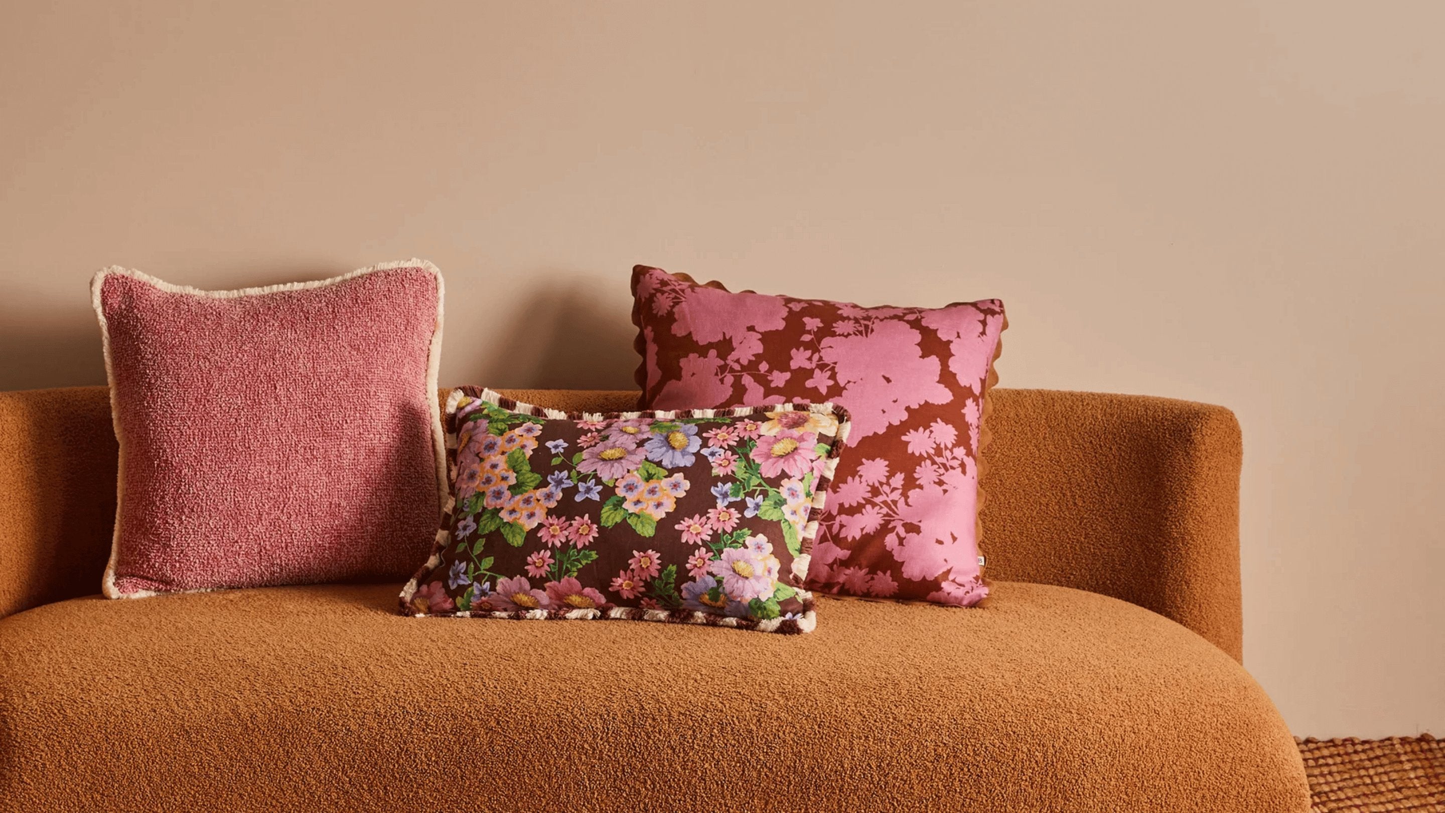 Daphne Rose Cushion | Pink floral cushion styled on tan sofa
