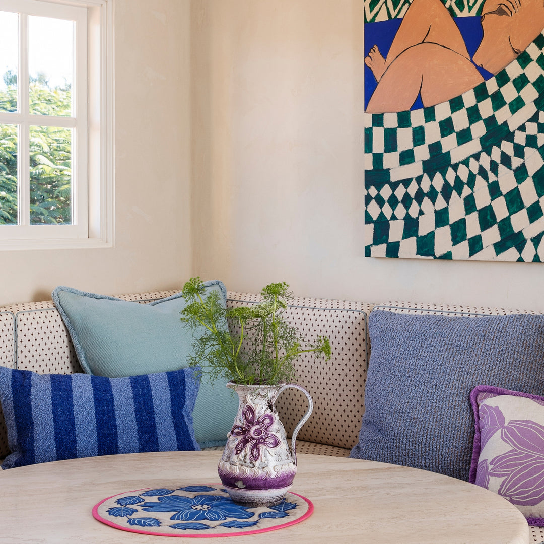 Levan Blue 60cm Woven Linen Cotton Cushion Styled On Banquette Seating With Margot Lilac, Boucle Stripe Blue & Cloud Blue Cushions