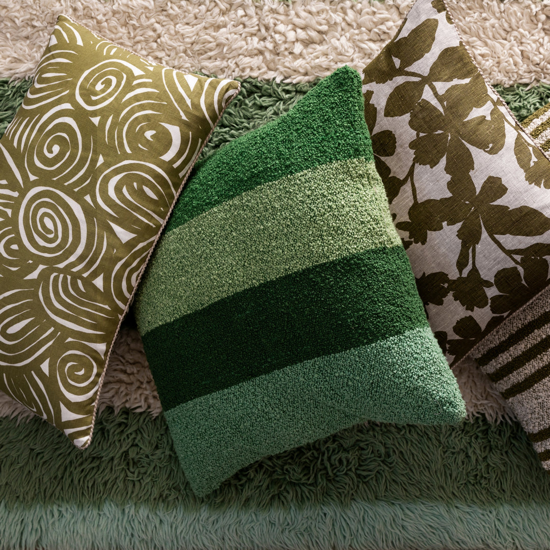 Wide Stripe Green 60cm Boucle Cushion Styled On Striped Rug With Complementary Cushions