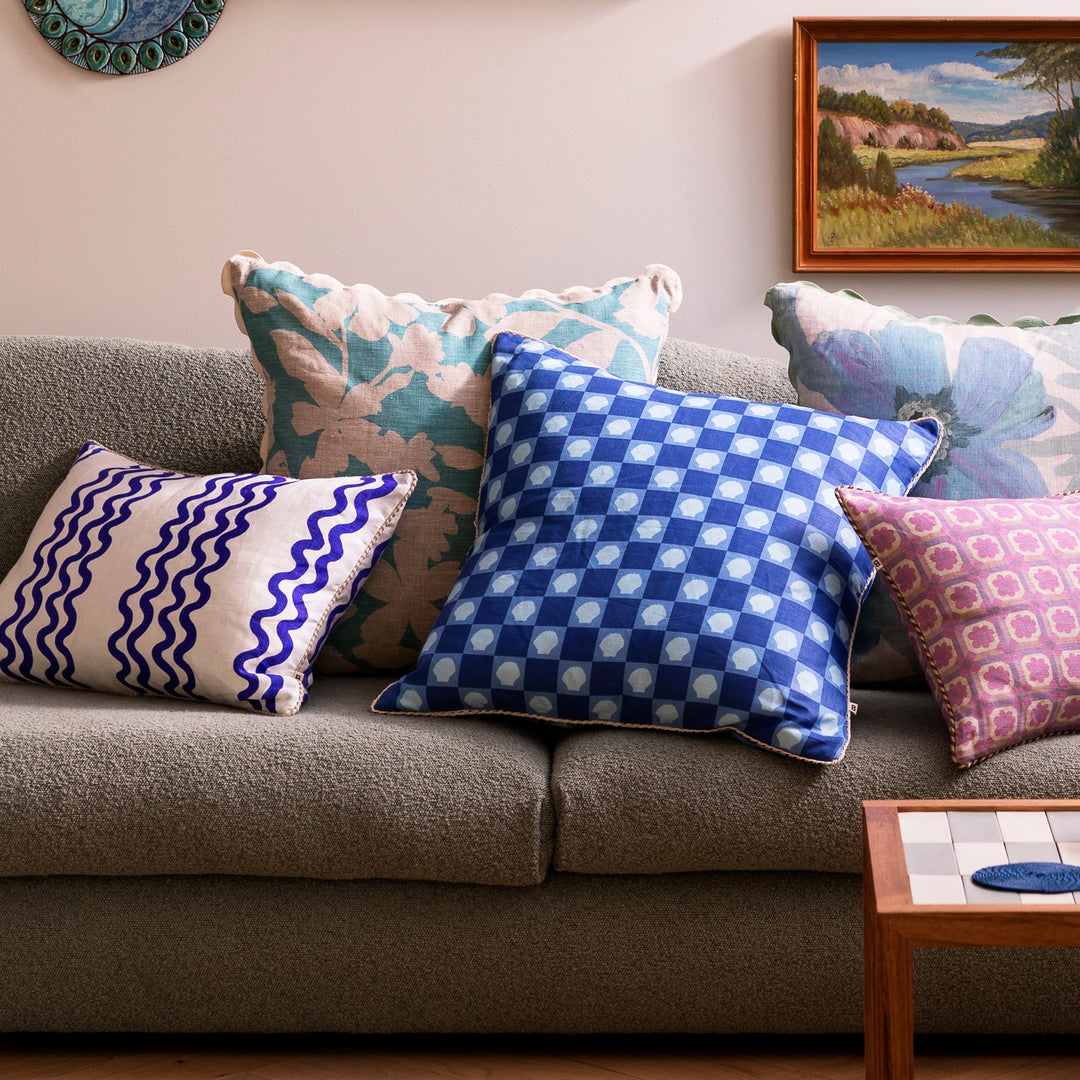 Shell Check Blue 60cm Linen Cushion Styled On Blue Sofa With Complementary Cushions