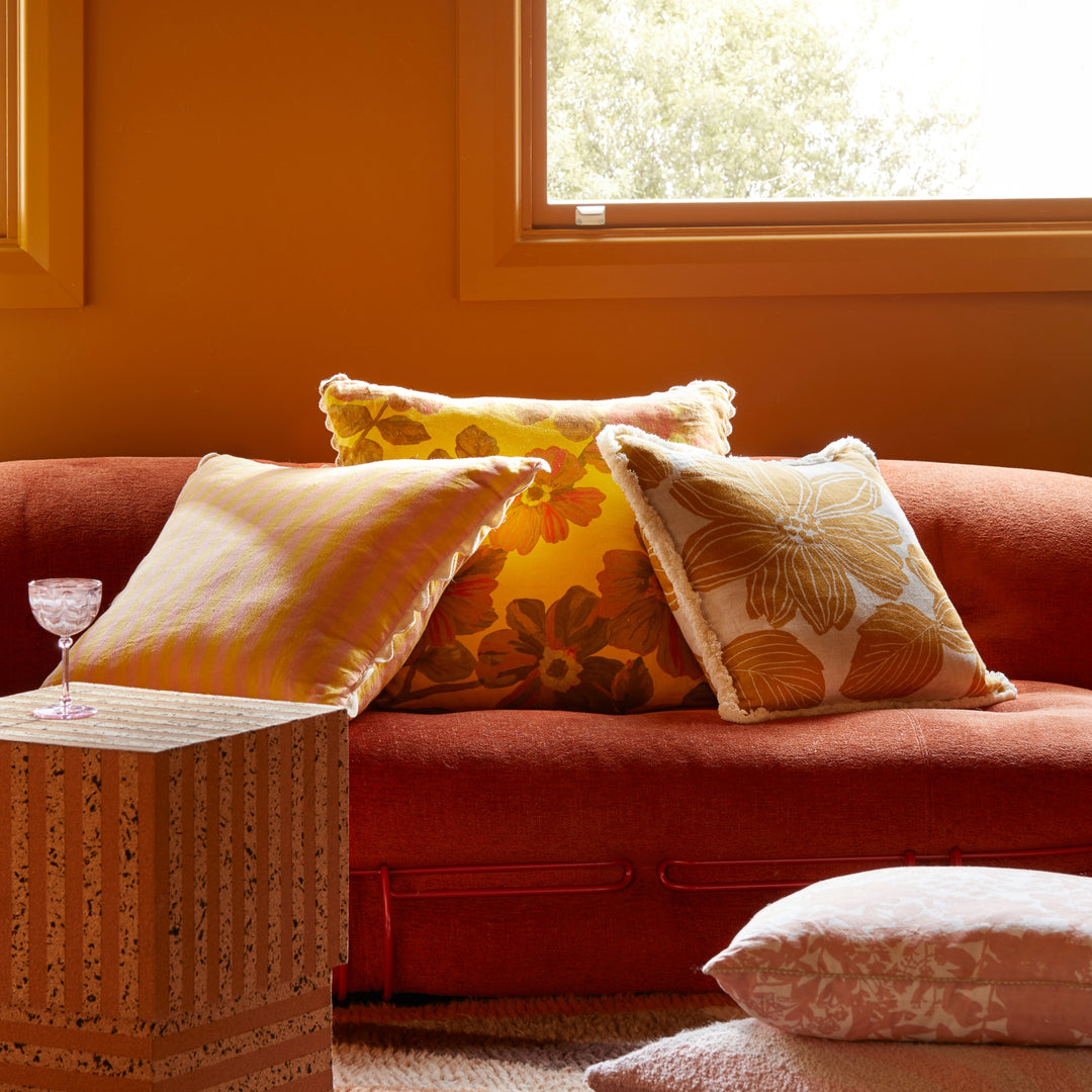 Rosetta Saffron 60cm Cushion Styled On Red Sofa With Thin Stripe Yellow Cushion & Margot Mustard Cushion