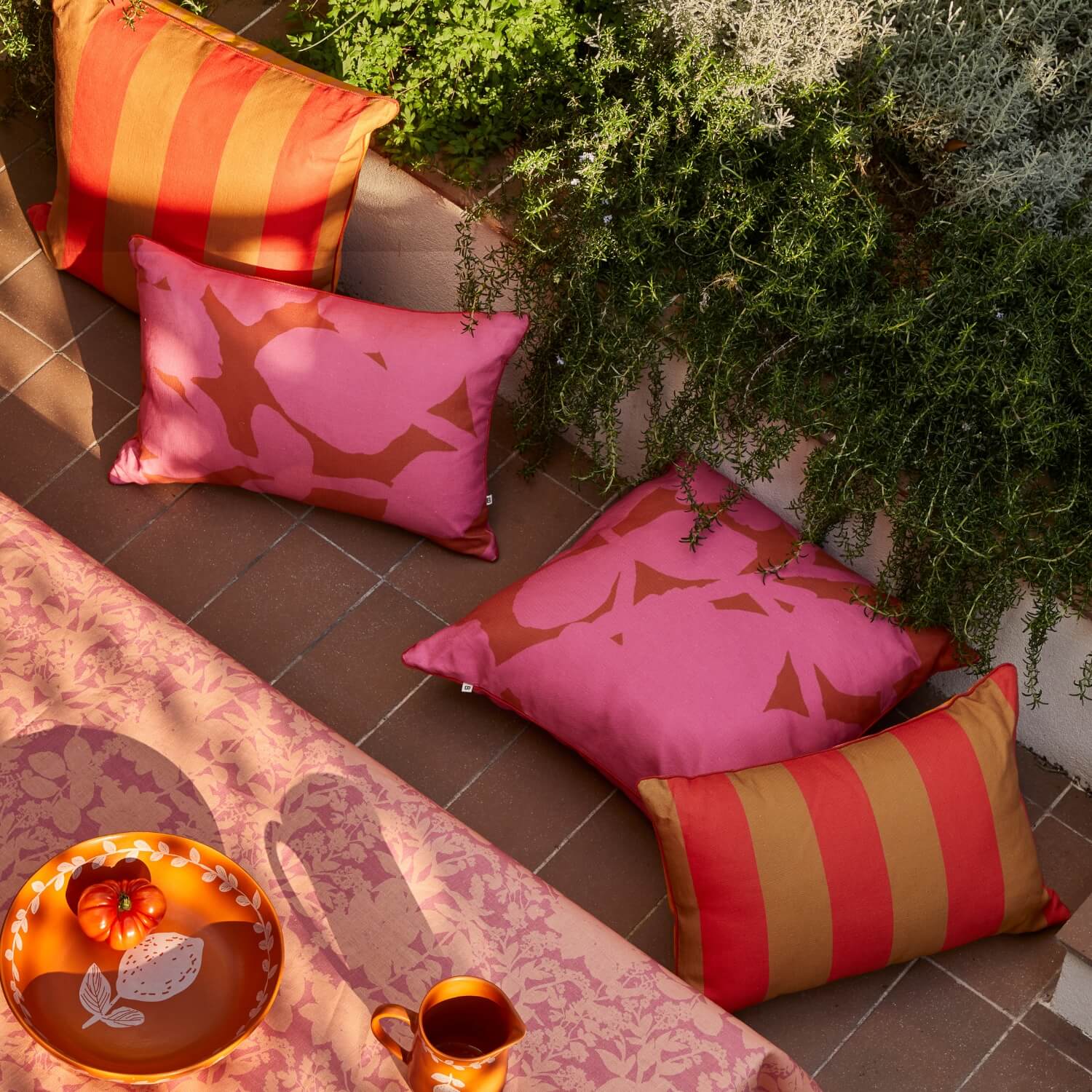 Carmine Pink & Big Stripe Orange Outdoor Cushions Styled In Outdoor Dining Setting With Herbs Reverse Pink Peach Linen Tablecloth