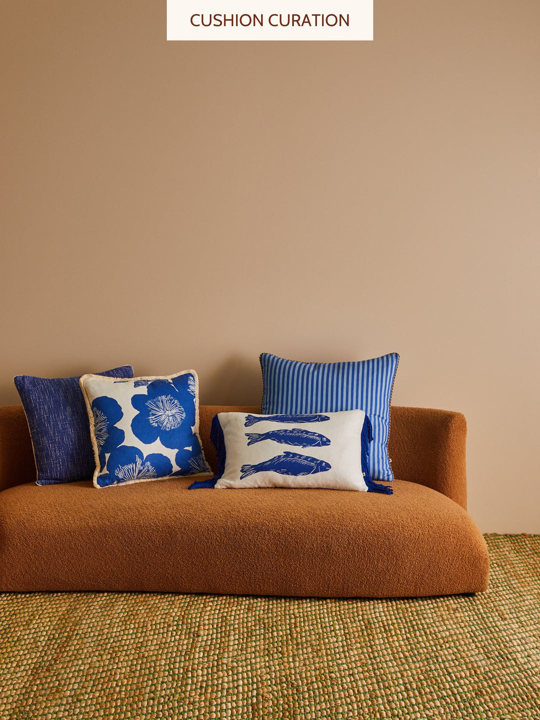 Brown sofa with blue and white patterned cushions against a beige wall.