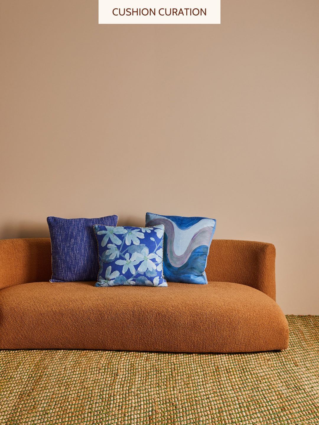 Brown sofa with blue patterned cushions against a beige wall