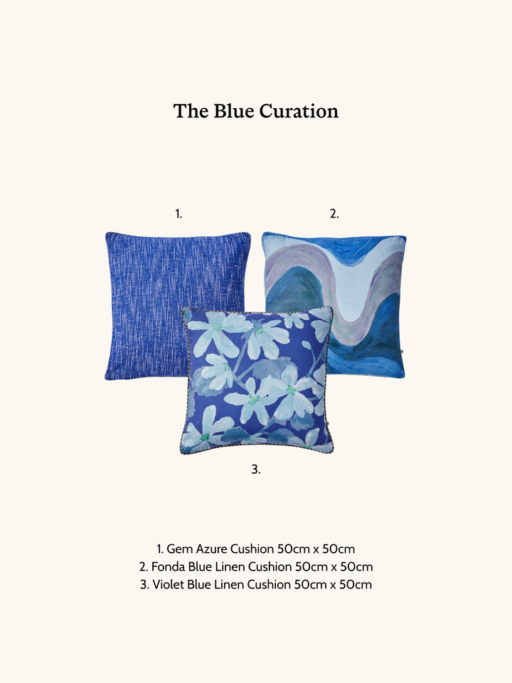 Three blue cushions with floral patterns on a white background, labeled 'The Blue Curation'.