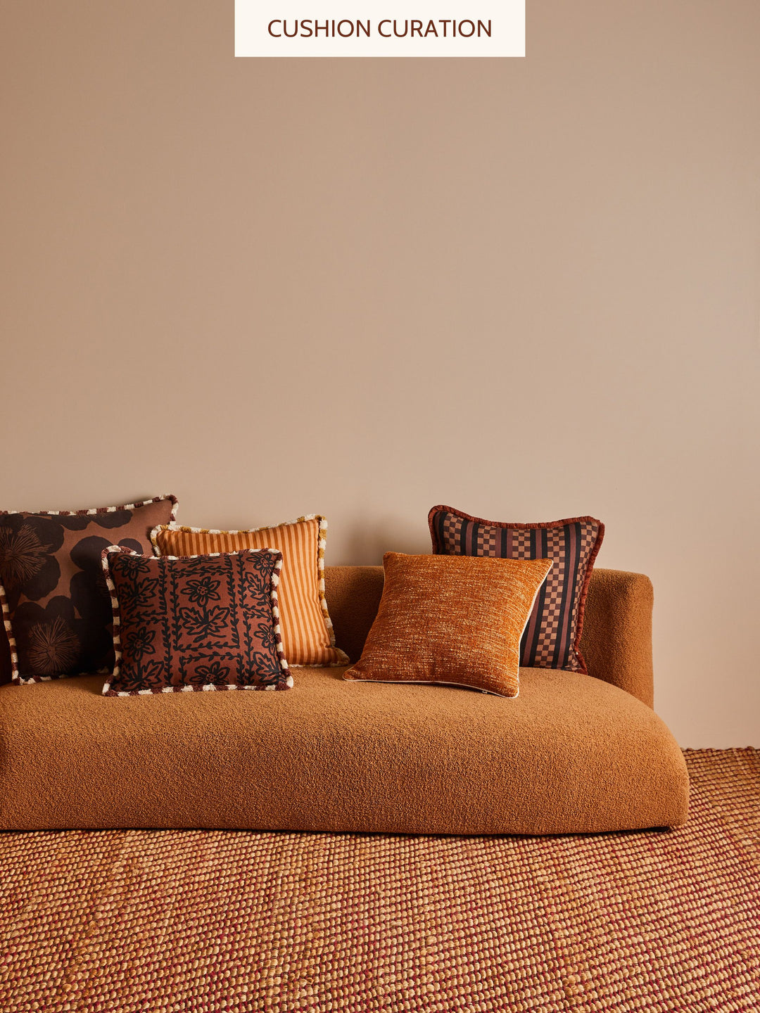 Brown sofa with patterned cushions against a beige wall, labeled 'Cushion Curation'.