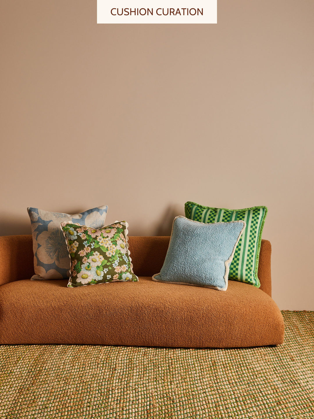 Brown sofa with blue and green cushions against a beige wall
