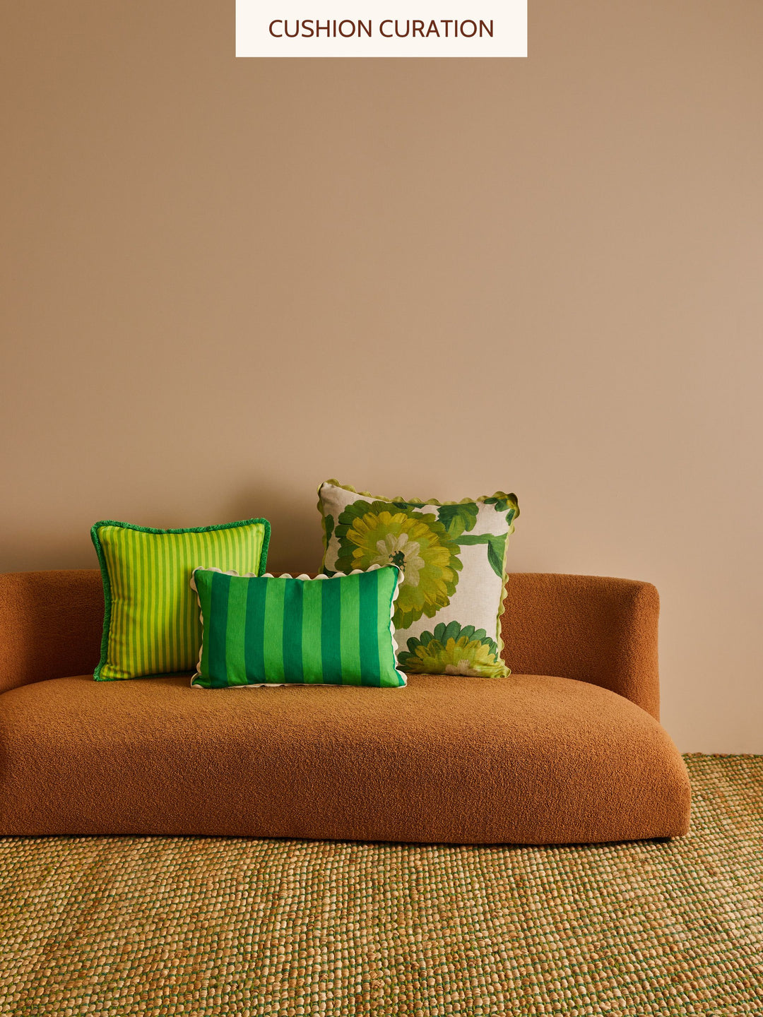 Brown sofa with green and patterned cushions against a beige wall